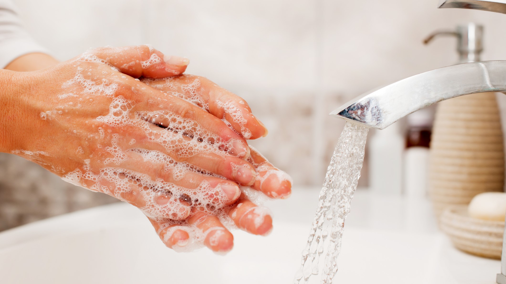 Handwashing A person washing their hands with soap and water in a sink.
