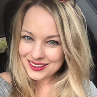 Melanie-Perdue White woman with light hair and gray shirt smiling
