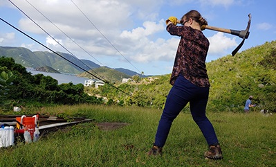 student swinging a oick axe on a farm Student swinging a pick axe on a farm
