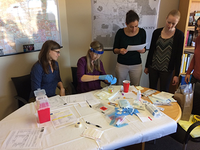 students doings labs Group of EEP students looking at a sameple of urine culture.