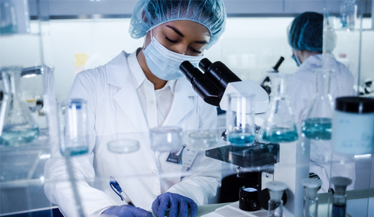 workforcefinal.jpg Laboratory workers in lab looking through microscope and writing down findings.
