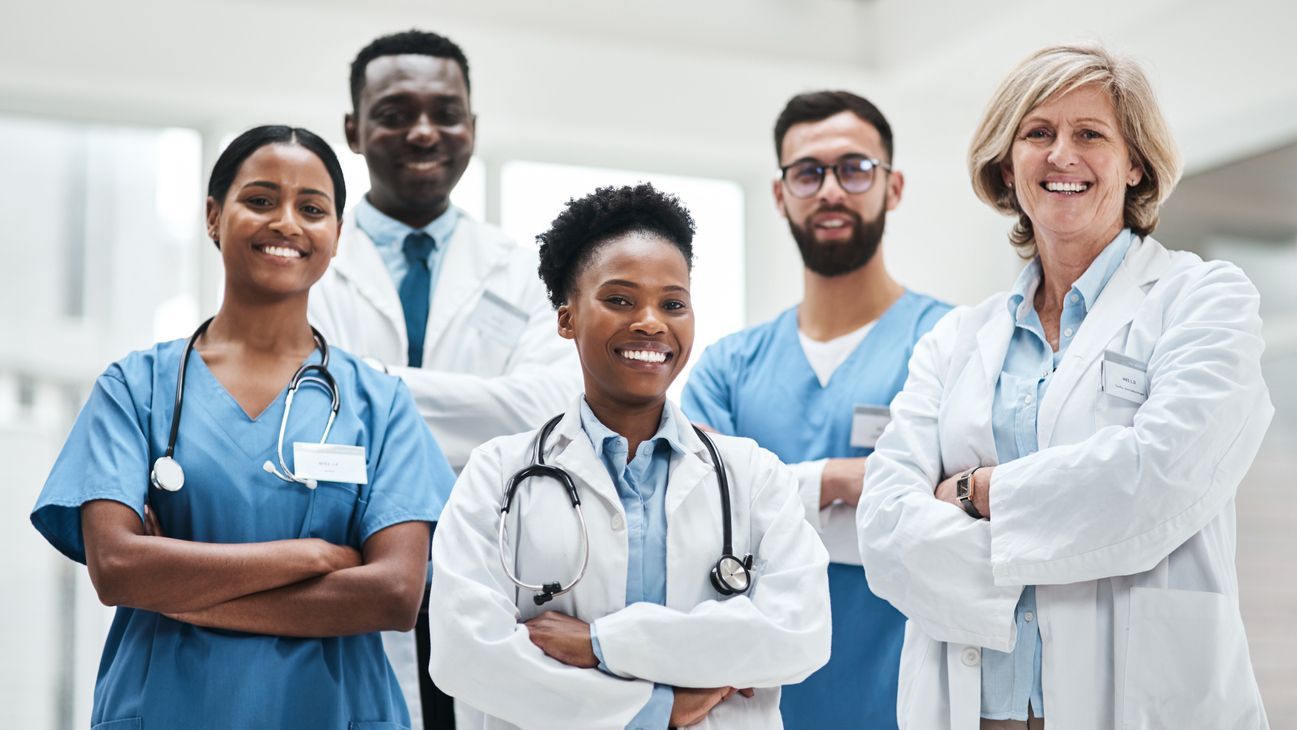 Diverse group of doctors smiling with arms crossed Diverse group of doctors smiling with arms crossed