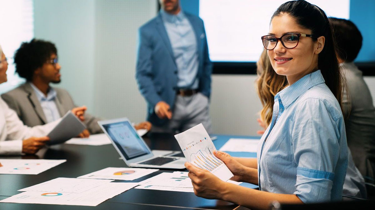 Woman wearing glasses holding a data sheet