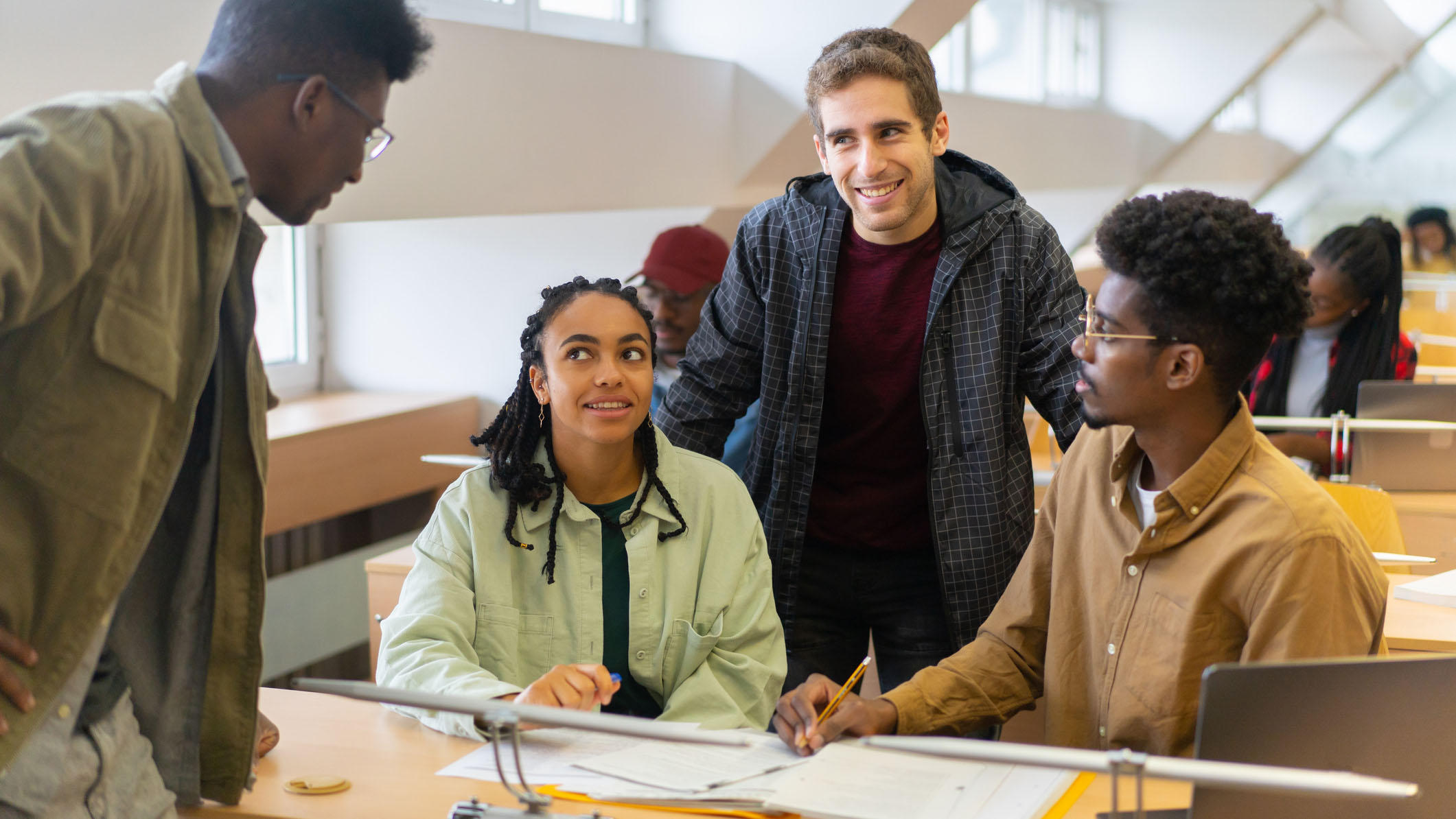 Foreign students chatting together in a lecture hall A multiracial group of undergraduates are talking with each other after a class at university