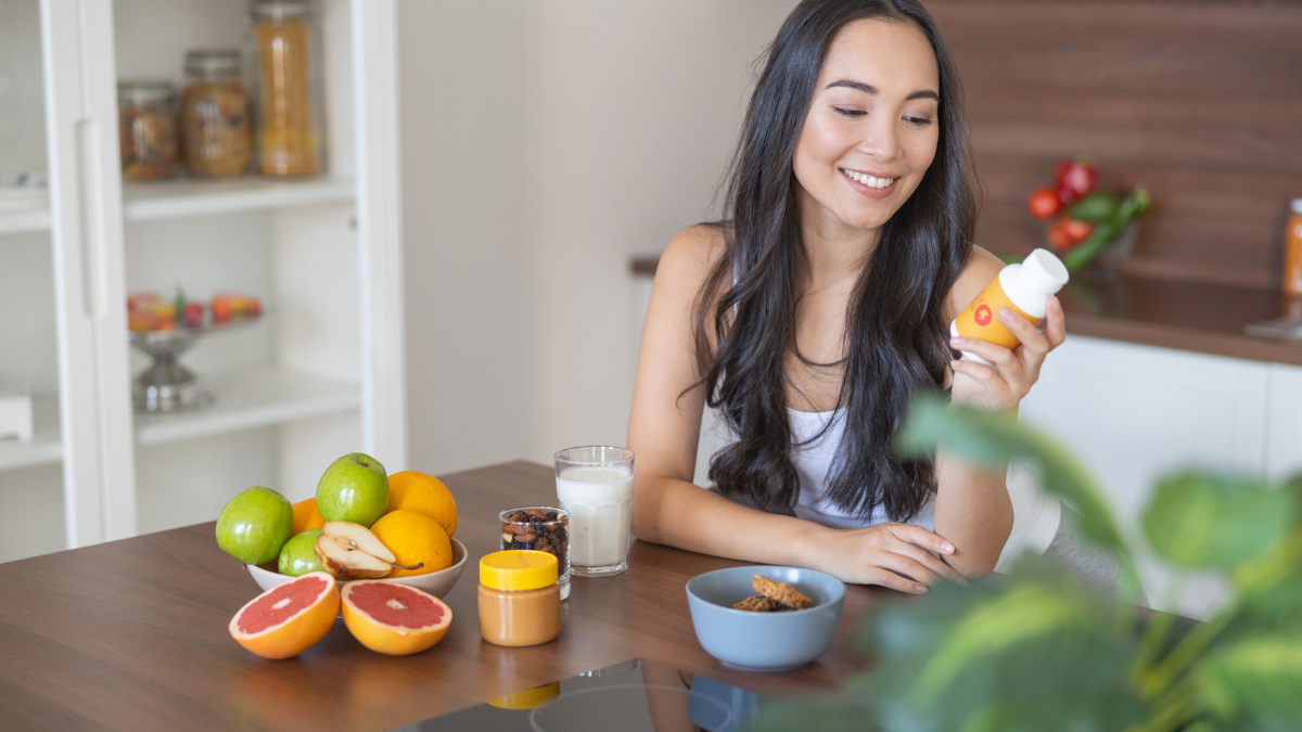 — title missing — Young adult taking a supplement at breakfast