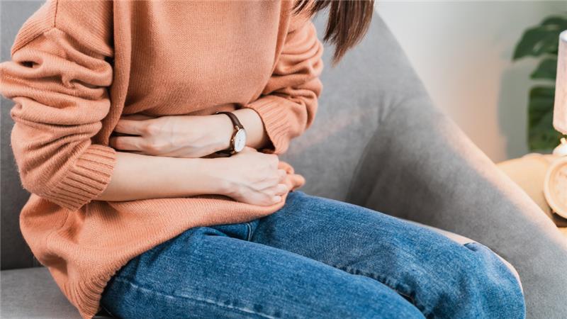 A woman with cramps holding her stomach