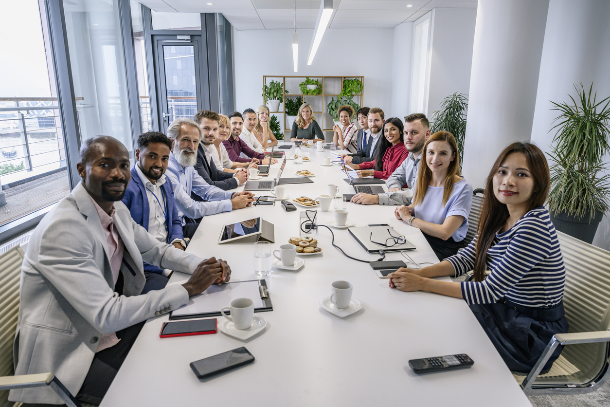 Food service guidelines team Food service guidelines team happily meeting around conference table in office.