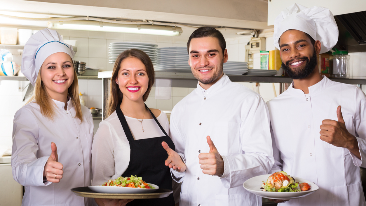 Chefs-recognition programs Four chefs or kitchen staff with healthy food giving a "thumbs up" sign.