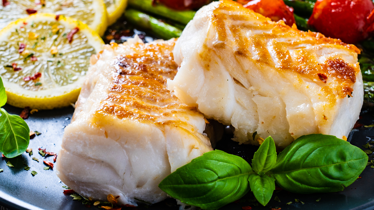 — title missing — Cooked fish entree plated with lemons and herbs
