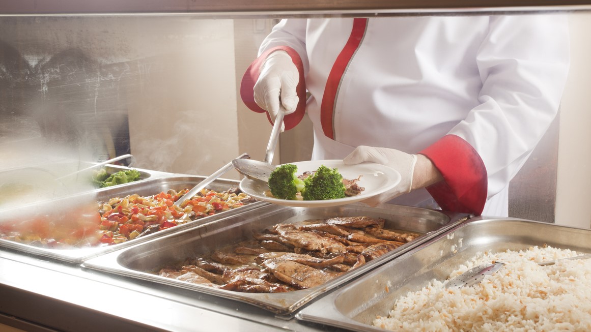 Food service line: roles and responsibilities Server dishing up a meal in a food service line.