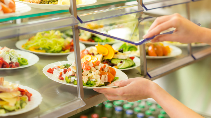 Salads in food service Close up of hands getting a salad in a food service setting