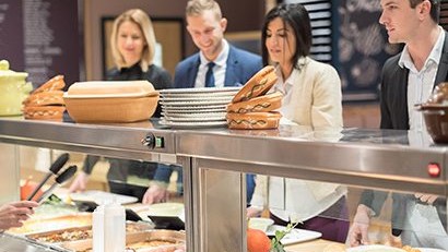 — title missing — Four young adults in cafeteria serving line.