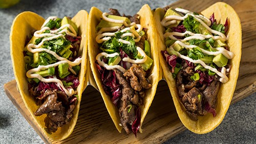 Tacos 16-9 Three tacos with steak, cabbage, avocado, and more.