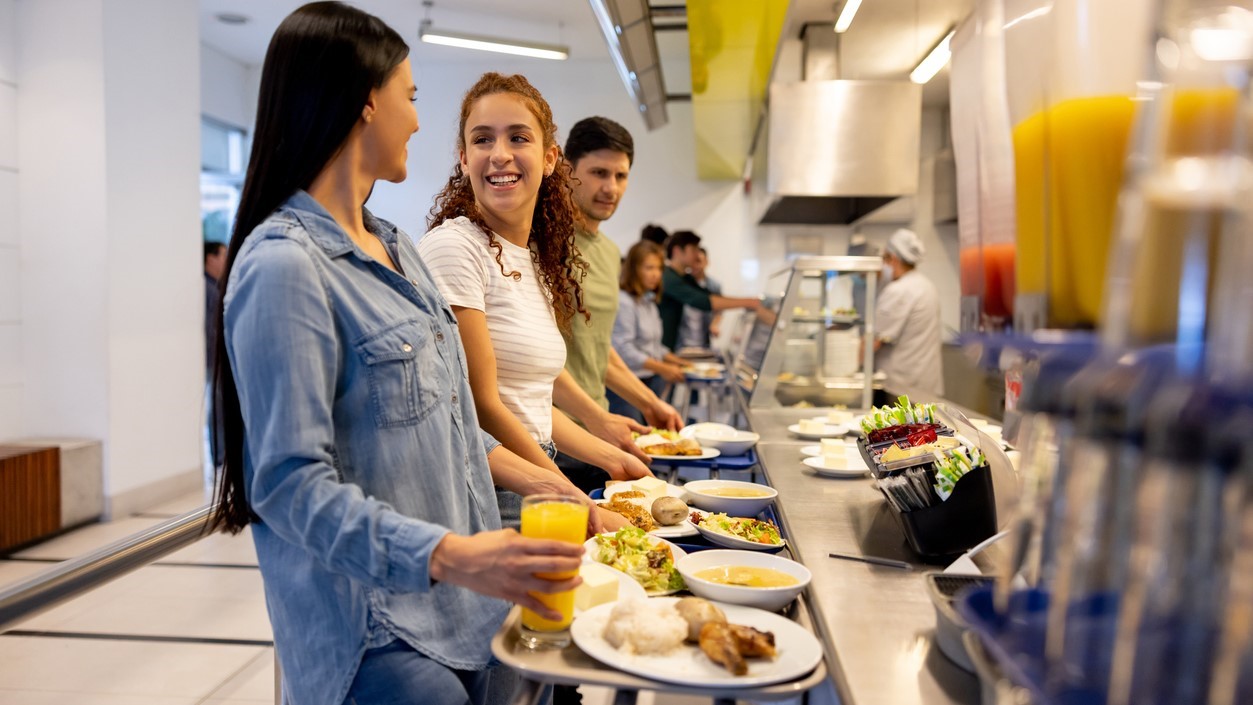 University serving line University-aged students going through cafeteria serving line.