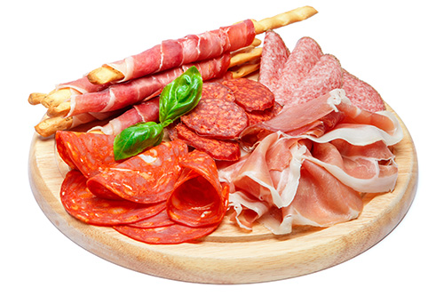 charcuterie board with multiple sliced meats
