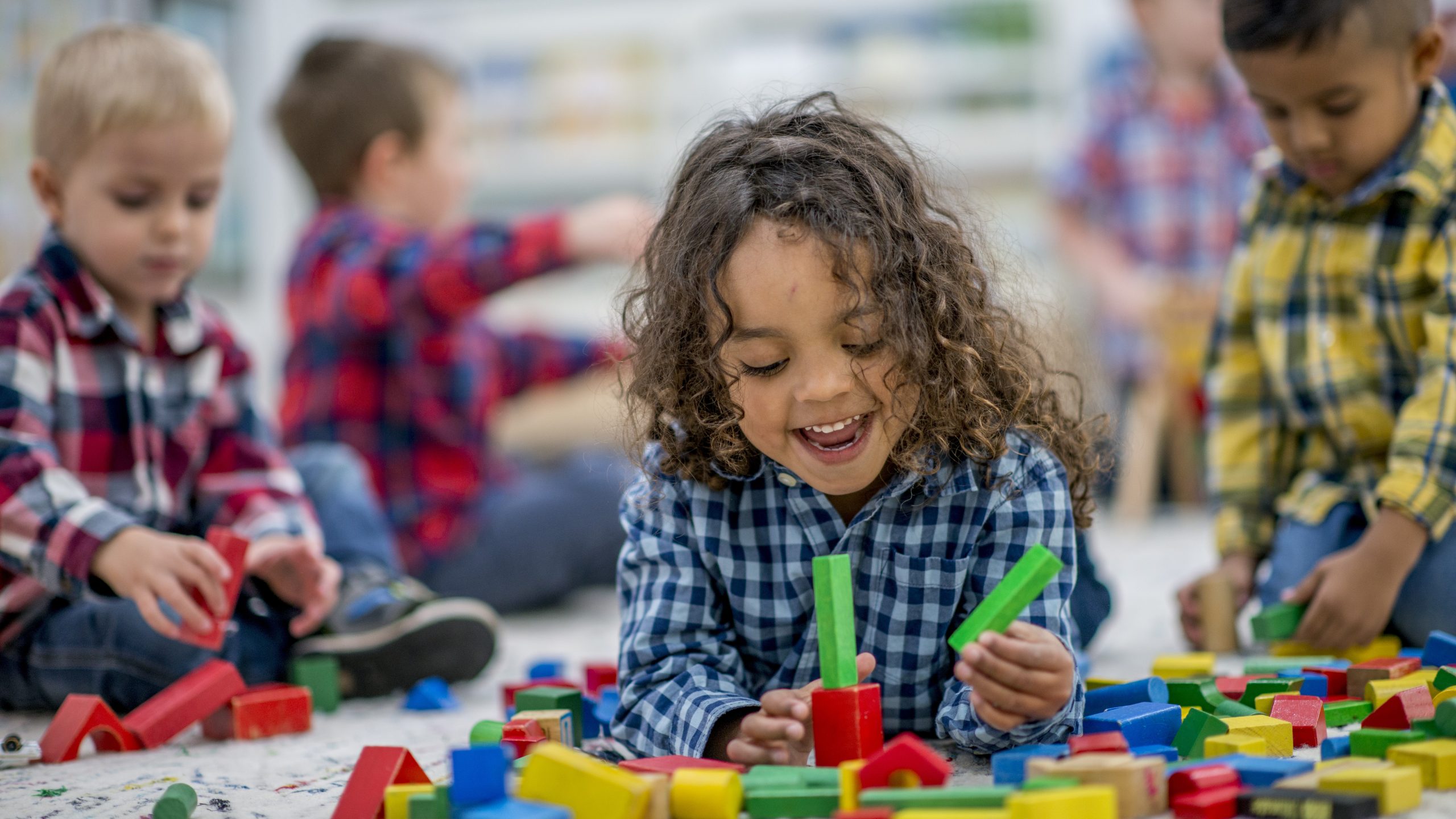 Kids playing in childcare Five young children playing with blocks and other toys