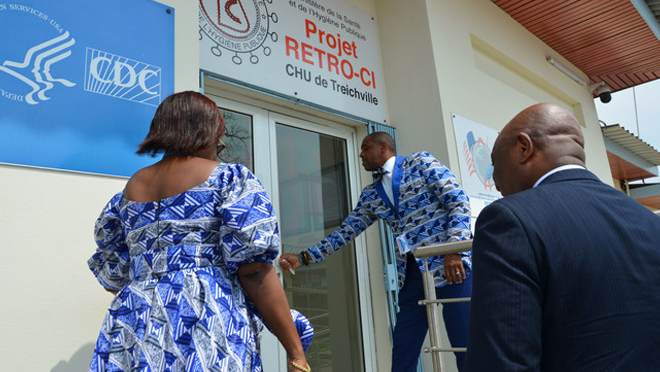 2023_SuccessStory_RetroCI Dr. John Nkengasong and two health officials open the door to walk into the Retro-CI lab.