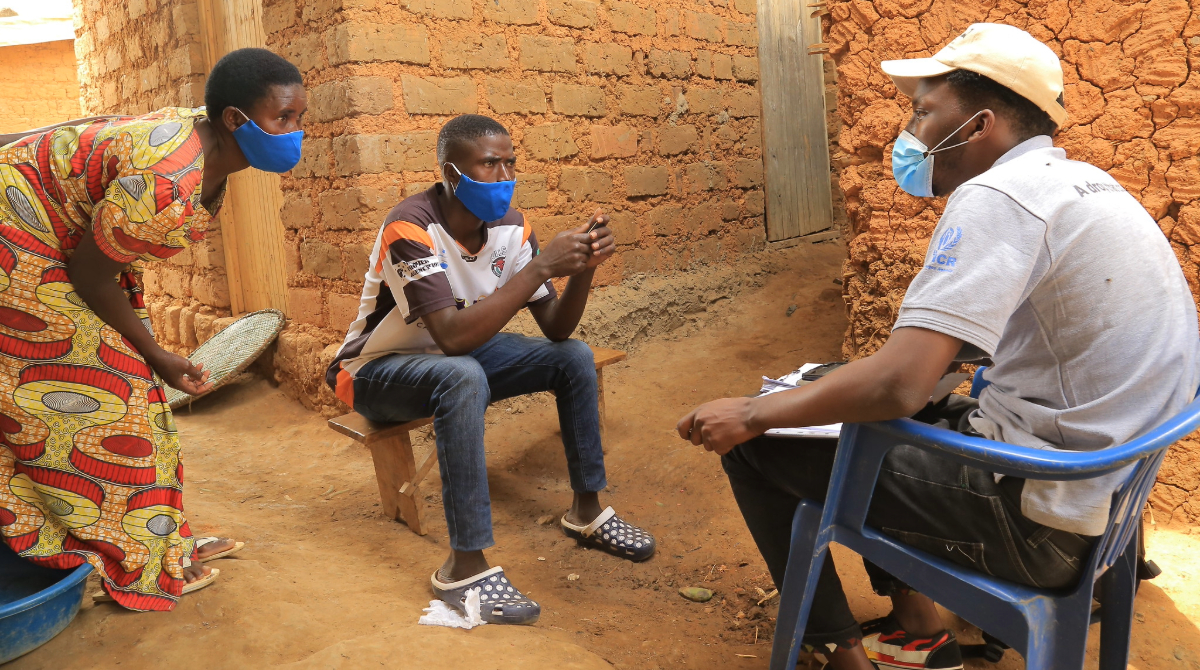 Uganda Refugee Survey Man interviews a man and woman in a Uganda community.
