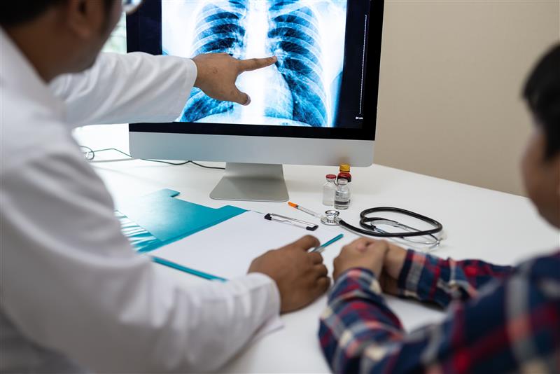 A physician reviews a chest X-ray.