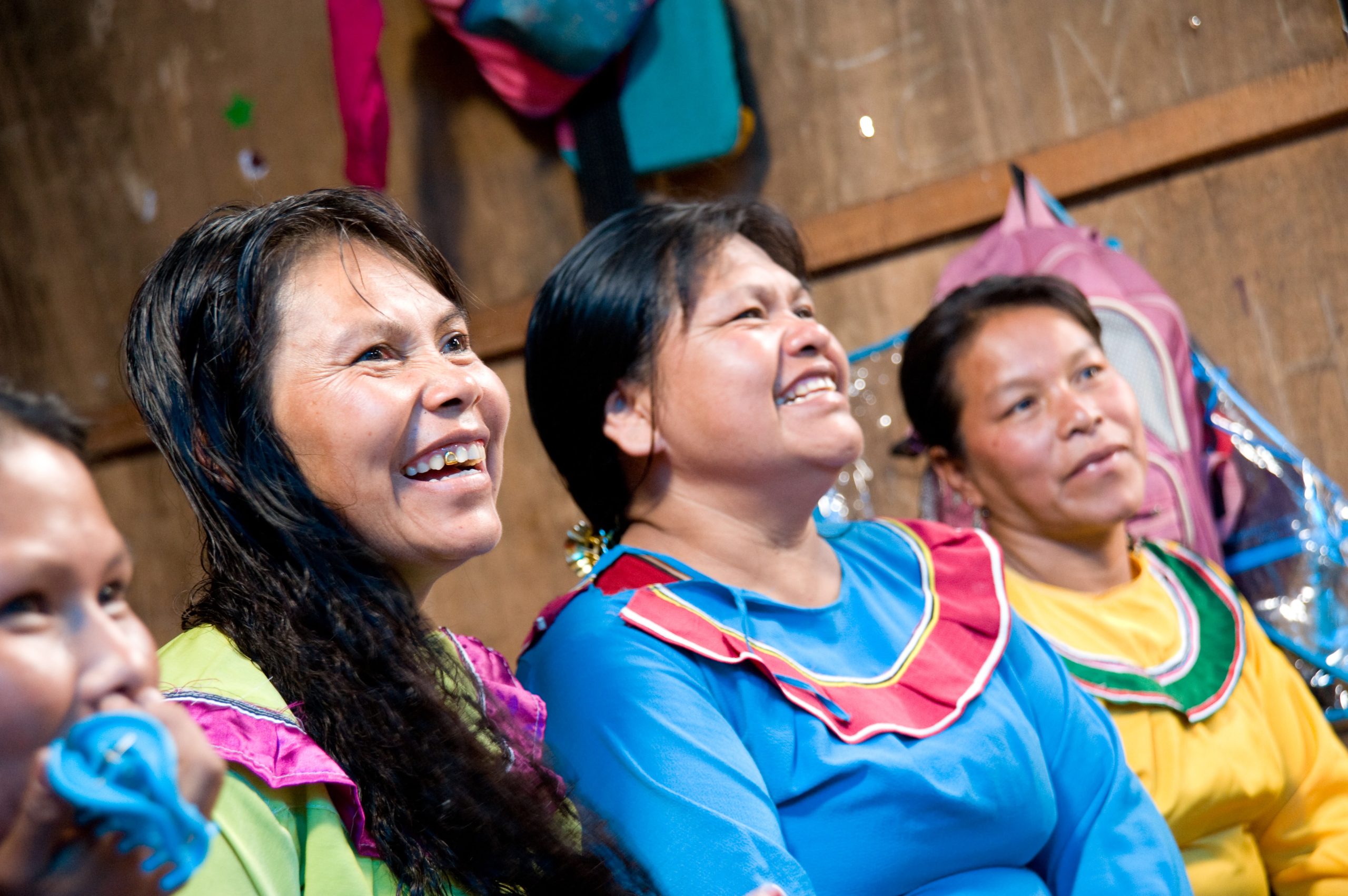 Smiling women in colorful shirts.