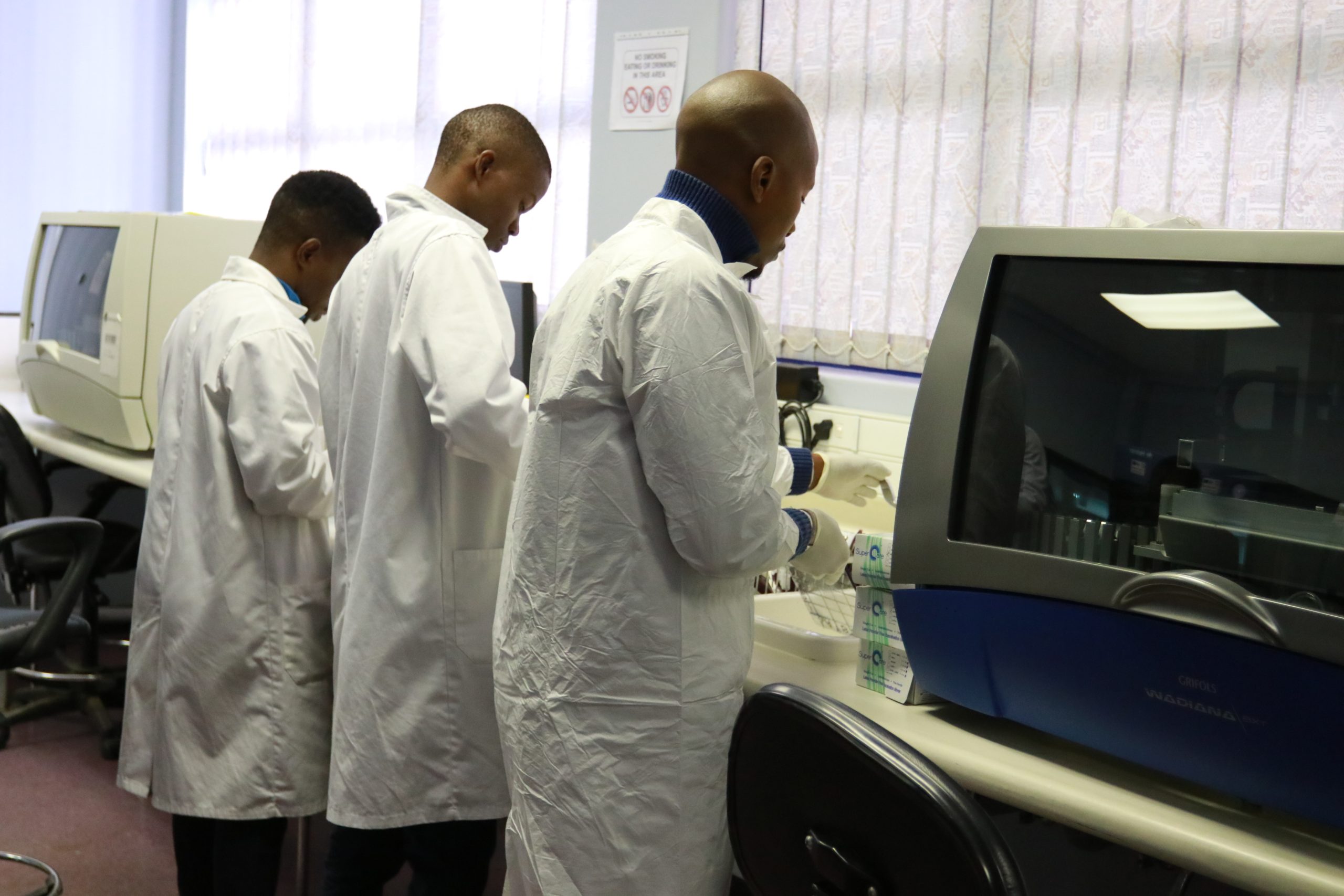Success Story Blood Bank 1 Laboratorians stand side-by-side processing blood donations.