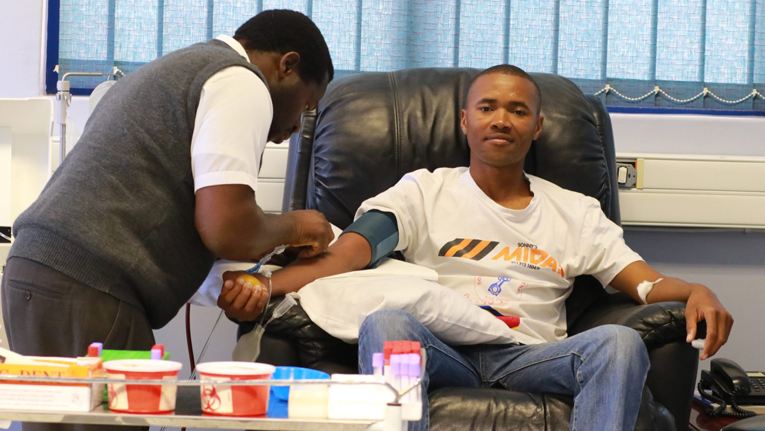 Success Story Blood Bank 3 Healthcare worker draws blood from a man