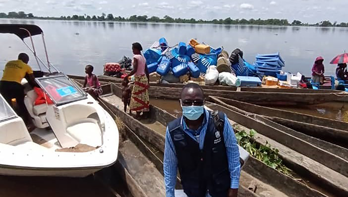 Health worker delivering vaccines by boat Health worker delivering vaccines by boat
