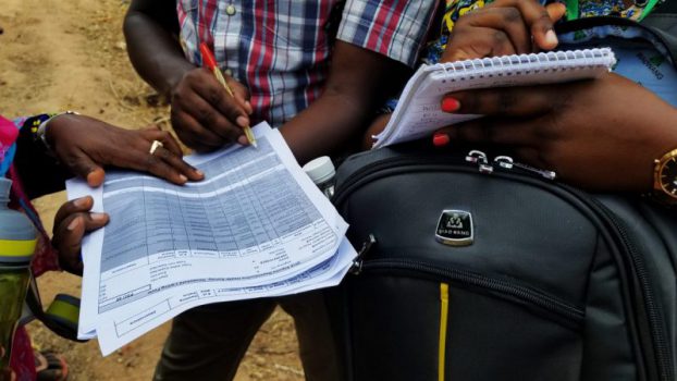 on-location-Tanzania people gathered around taking notes