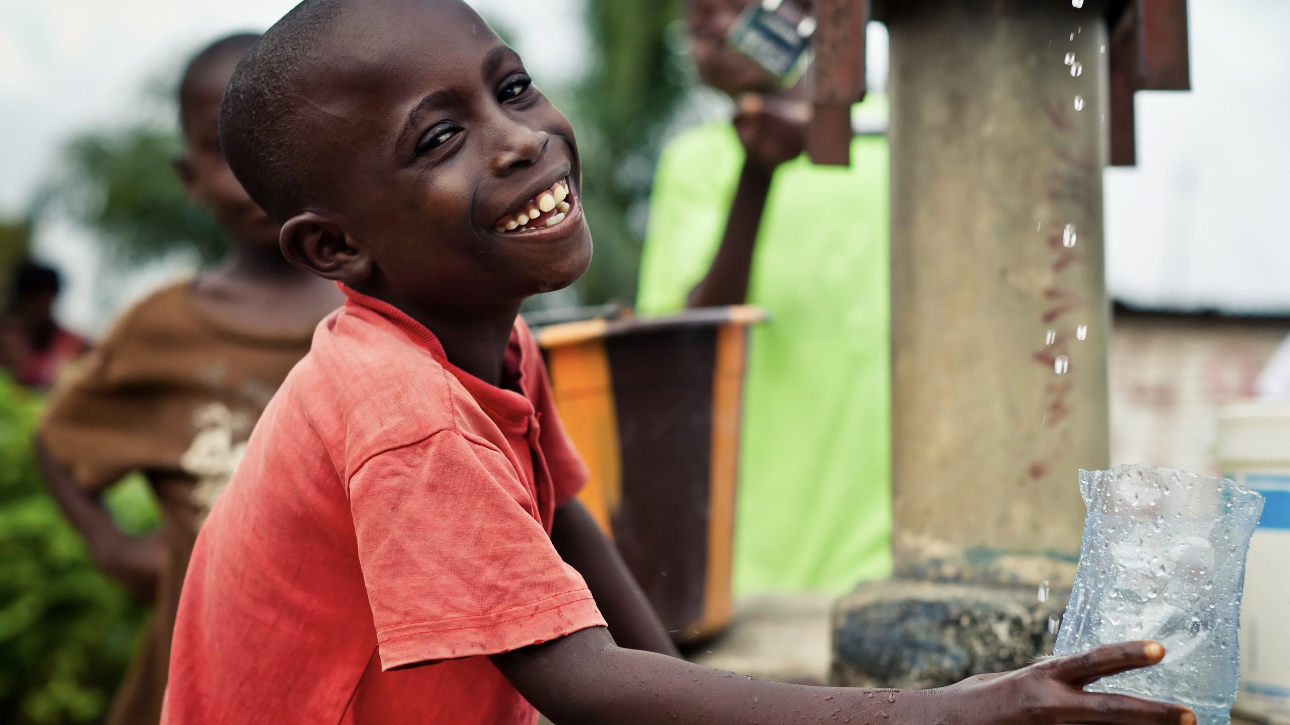 DrinkingWaterBoyAtPump Boy holding glass getting drinking water from a pump