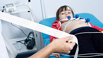 A doctor looks over results from a child’s electrocardiogram