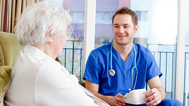 HCP and LTCF resident A healthcare provider checks on the blood pressure of a resident of a long-term care facility.