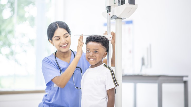 Boy on scales Boy getting his height measured by a nurse.