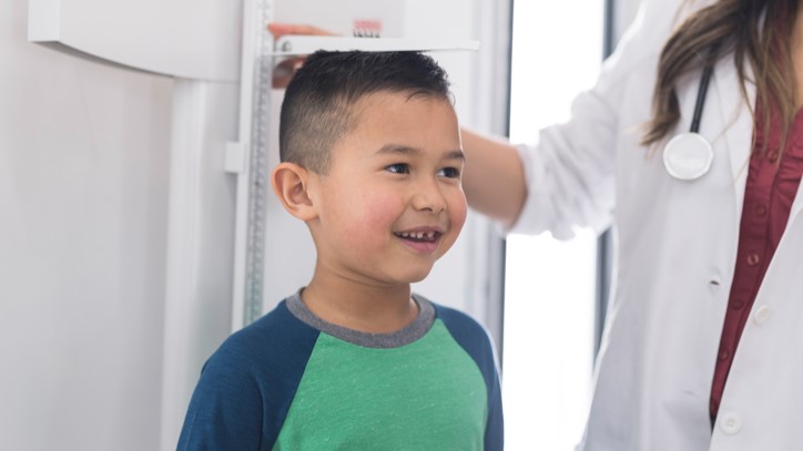 Measuring boy's height Health care provider measuring a boy's height.