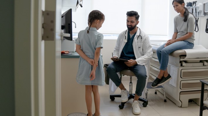 Mother & daughter with doctor Doctor sees pediatric patient while mother observes