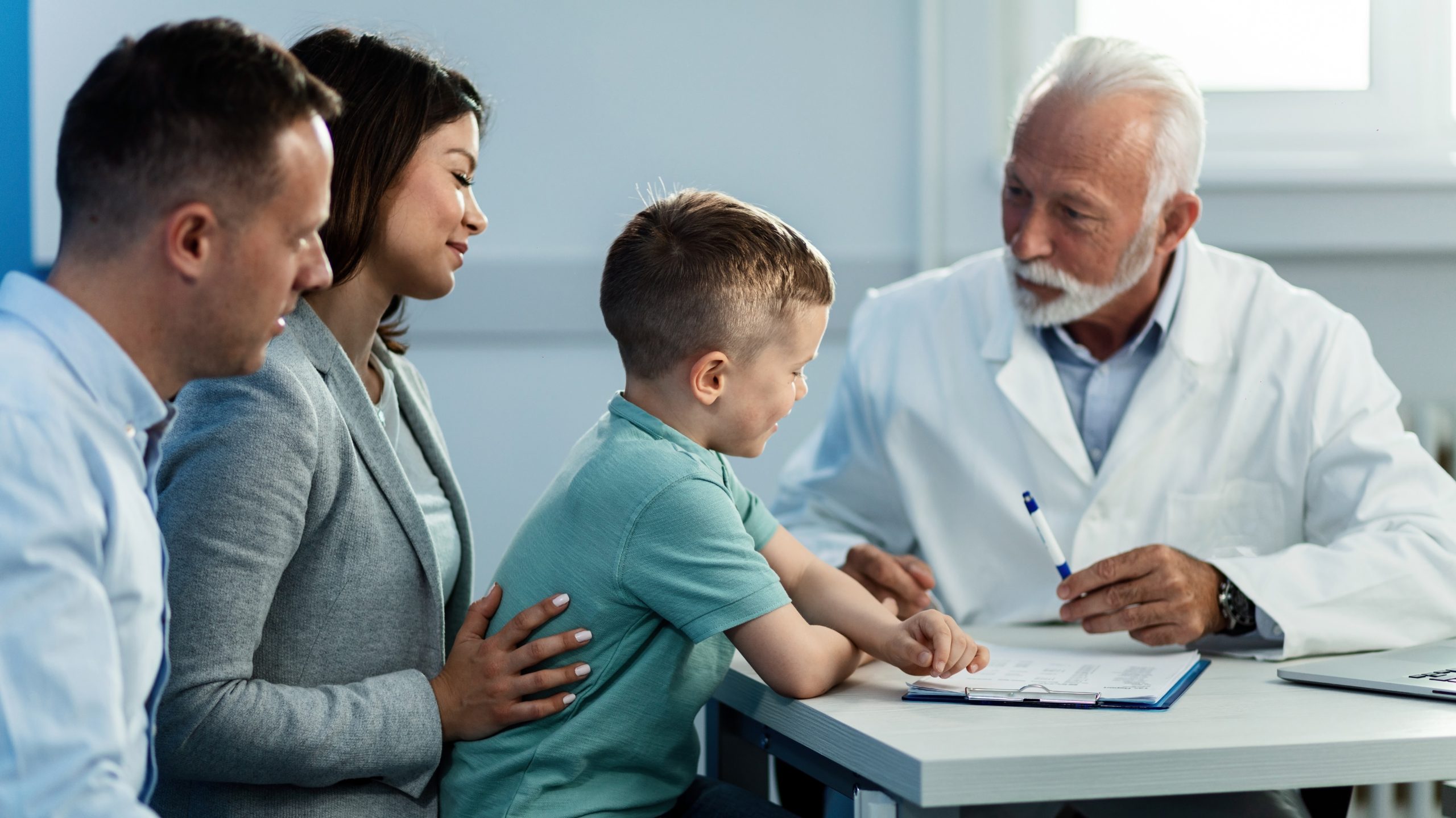 Health care provider talking to father and son A healthcare provider talking to a couple and their chlid.