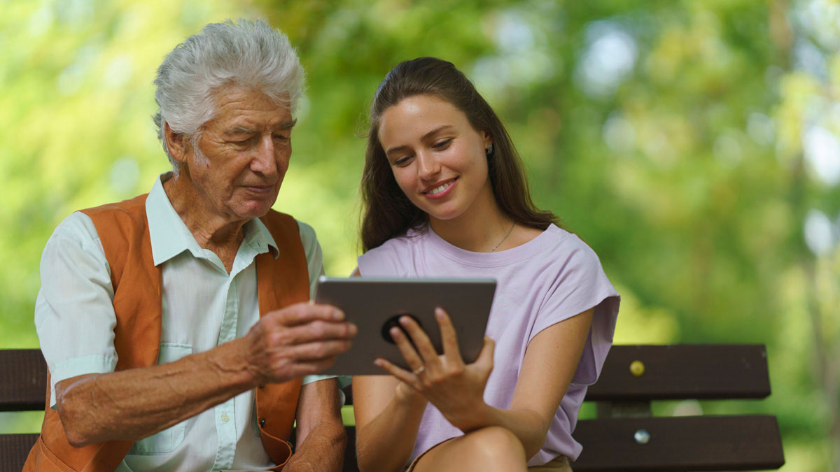 eHealth Literacy Caregiver helping senior man to shop online on tablet