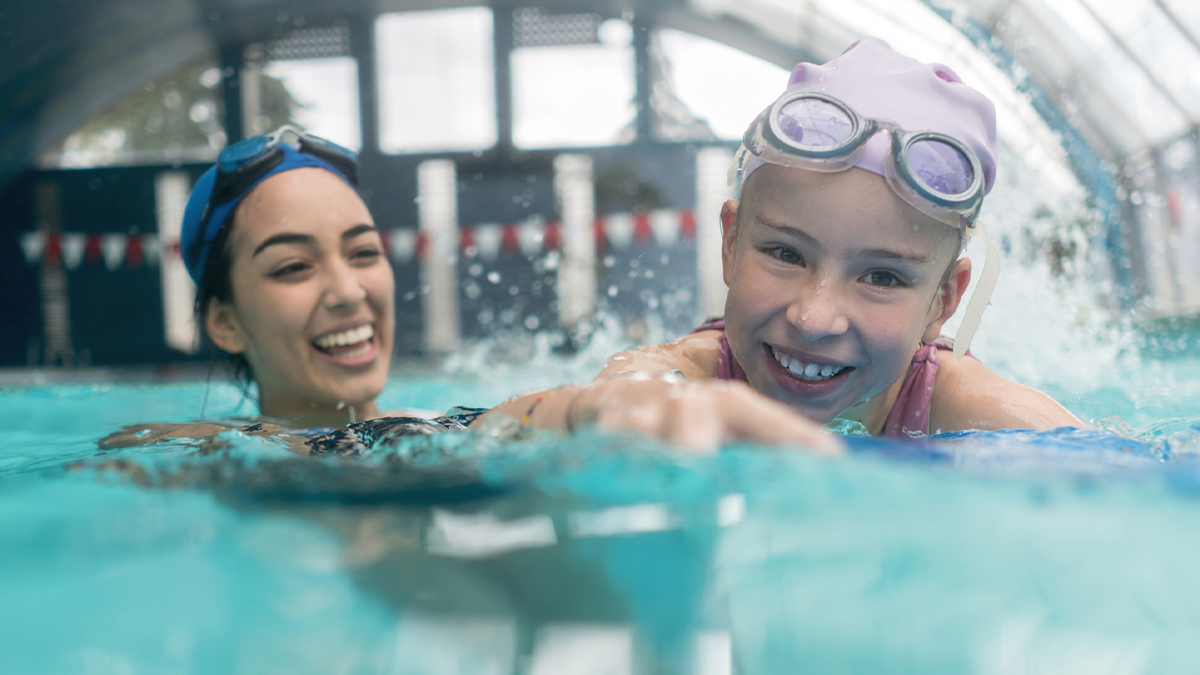 — title missing — Two girls swimming together in the water.
