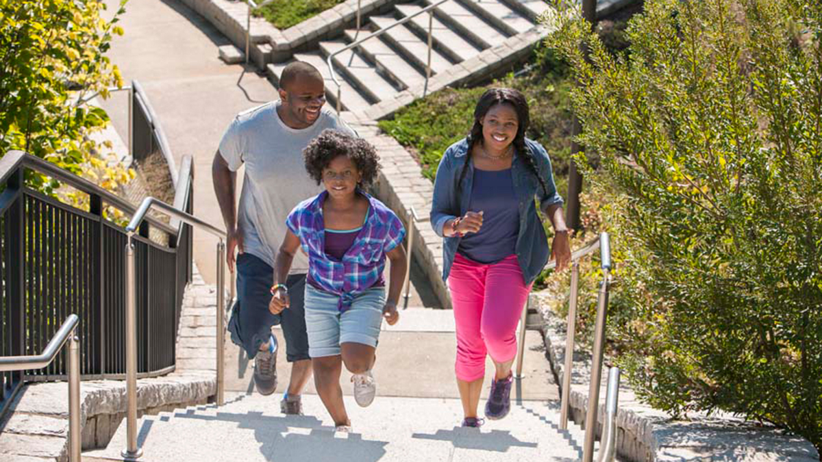 Family walking up an outdoor staircase. A family walking up stairs