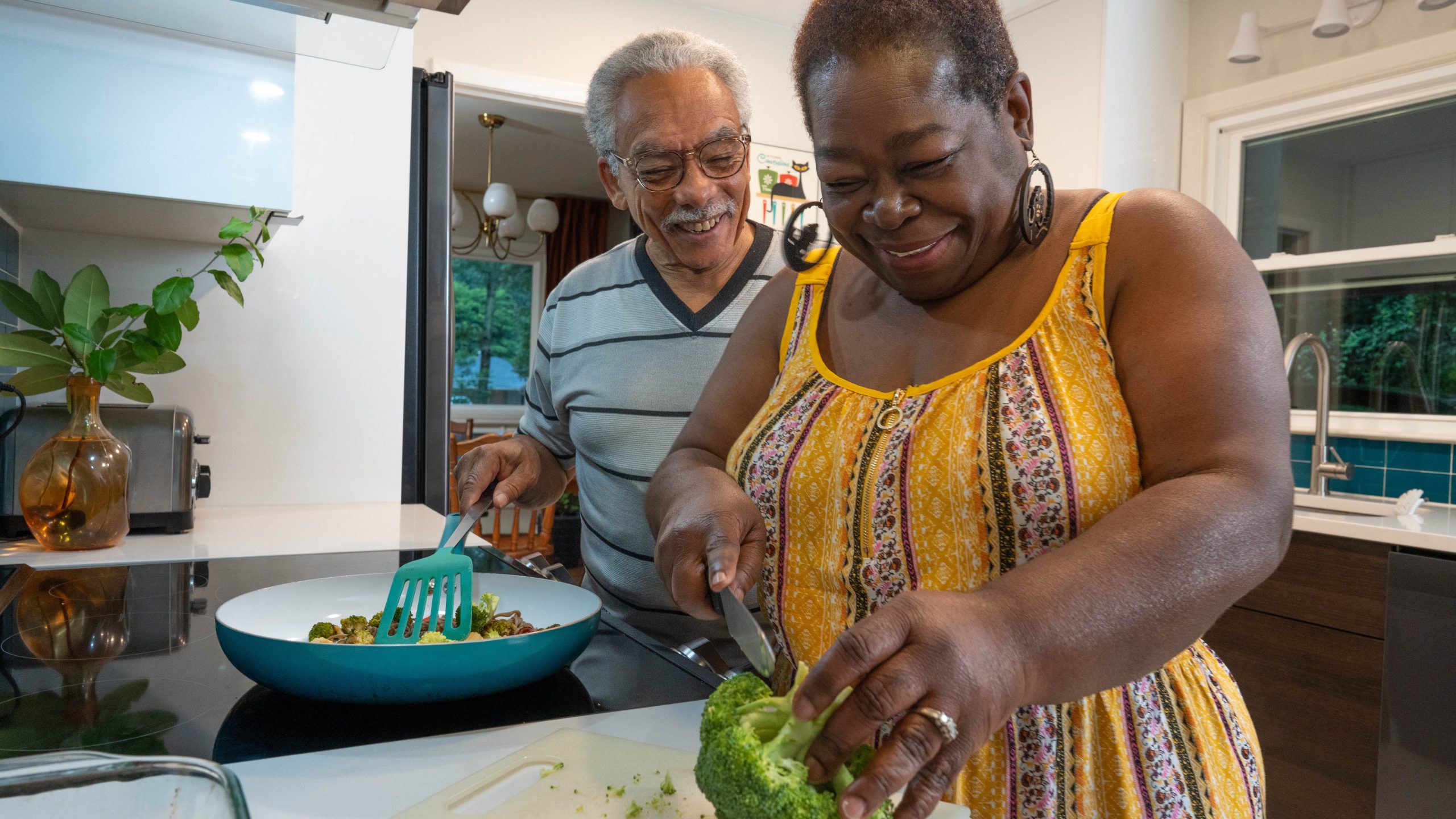 — title missing — Couple making a meal on the stovetop in a home kitchen.