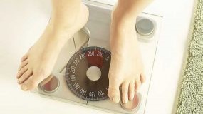 — title missing — Person's feet on home scales.