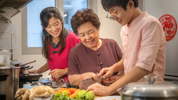 Asian Family Preparing Food Photograph of a son, mother, grandmother preparing bittermelon and chicken.