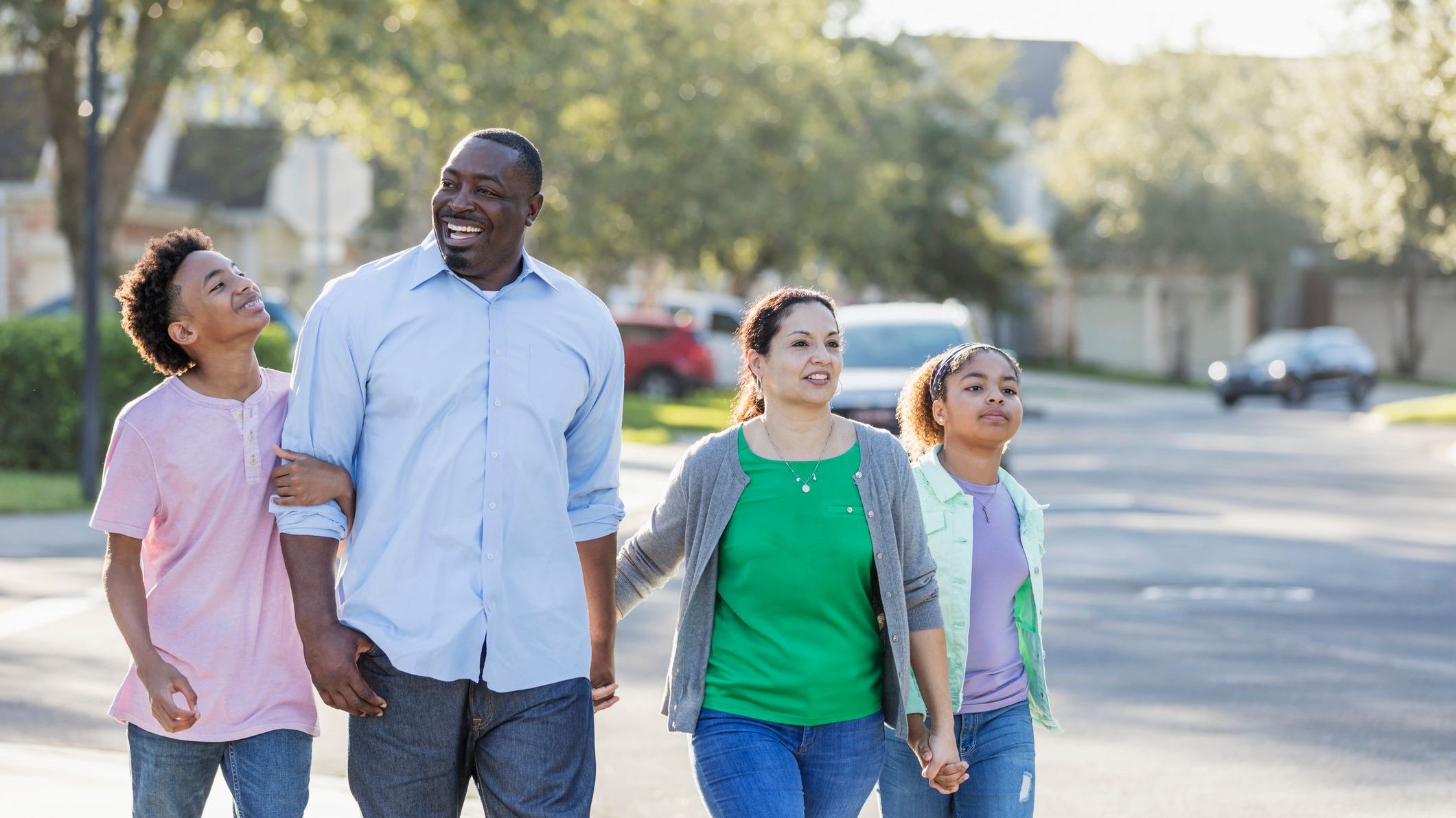 Information for parents A family with two children taking a walk together in a residential neighborhood.
