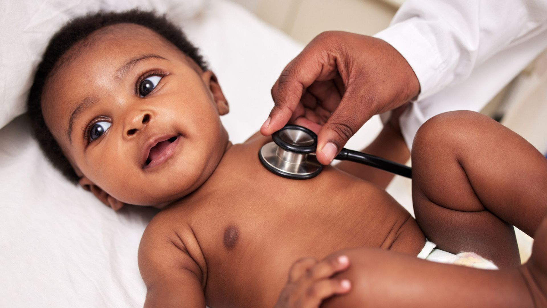 Caregiver listening to a baby's heart A baby having his heart listened to with a stethoscope