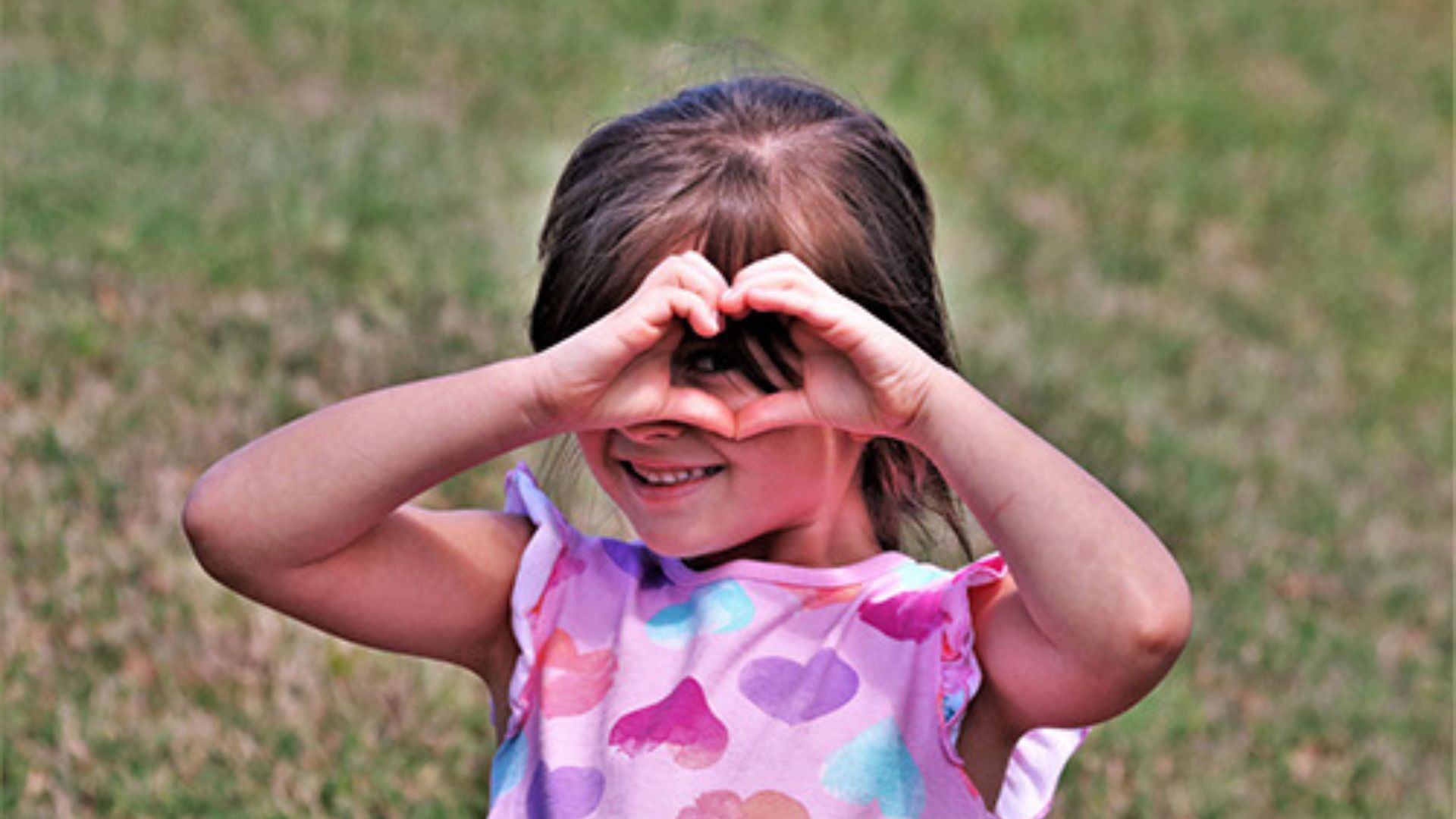 — title missing — Little girl making heart gestures