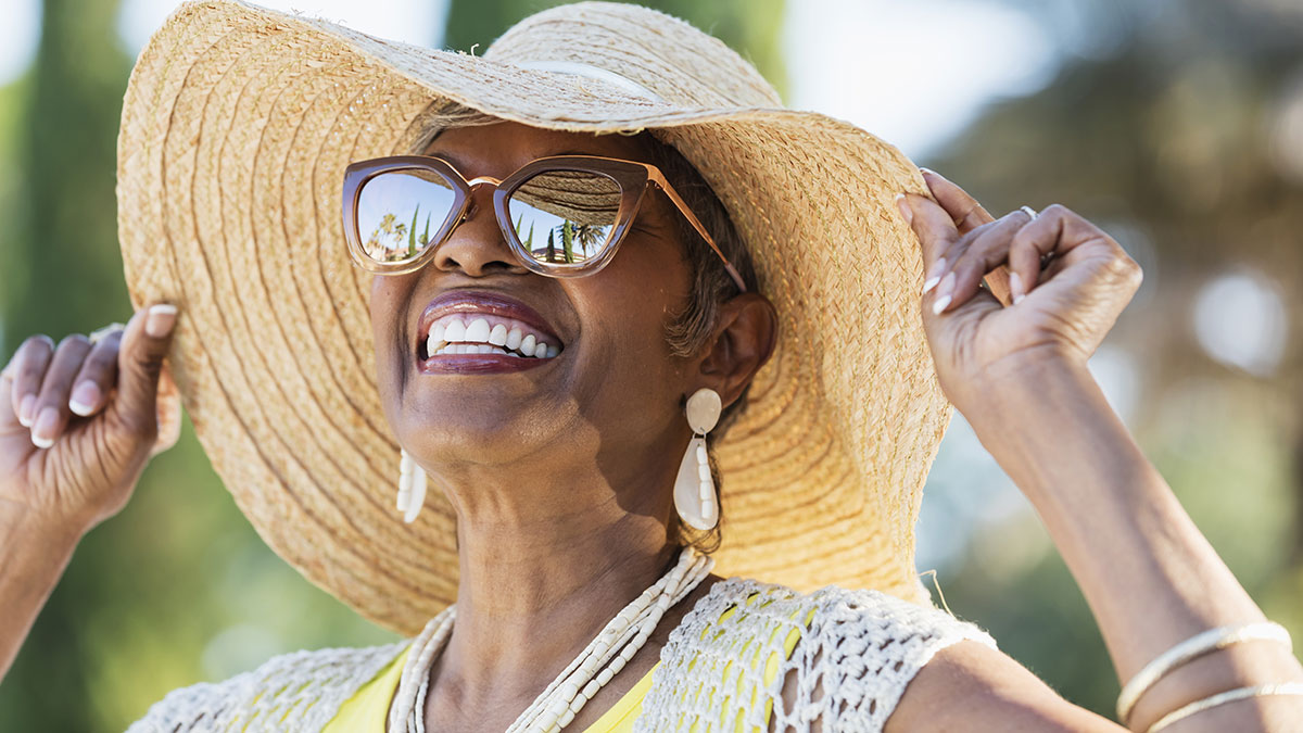 Woman wearing sunglasses and sun hat outside