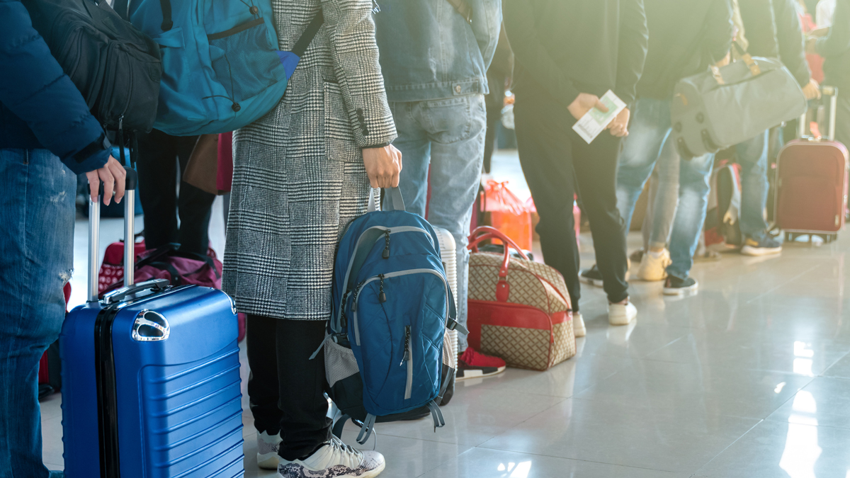 Hepatitis A Prevention and Control People waiting in line at the airport with their luggage