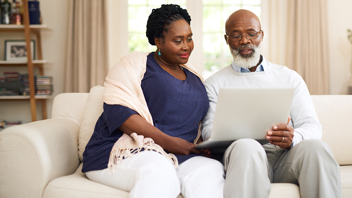 Hepatitis B Patient Resources Thumbnail A man and a woman sitting on a couch and looking at a laptop together