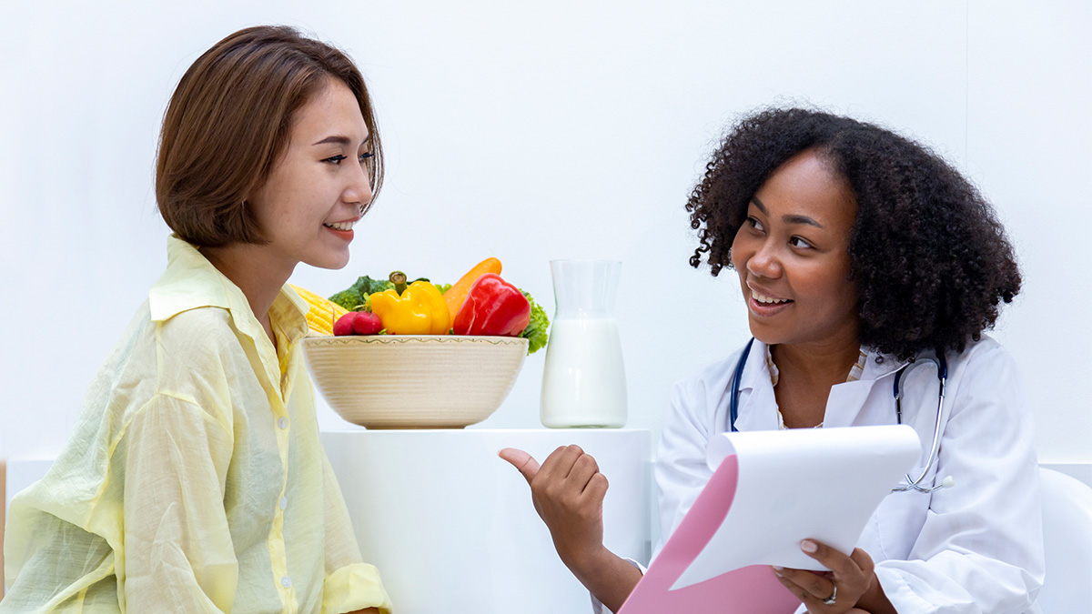 Hepatitis B Treatment Thumbnail A doctor sitting with a patient and showing her information on a clipboard