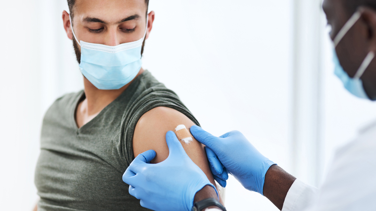 Hepatitis B Vaccine Administration A doctor placing a bandage over the vaccination site on a patient's shoulder