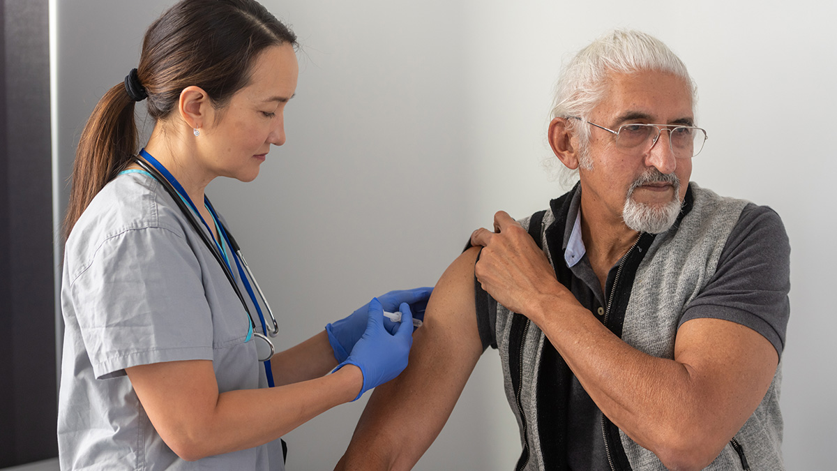 Hepatitis B Vaccination Thumbnail A healthcare professional giving a man a shot in his shoulder